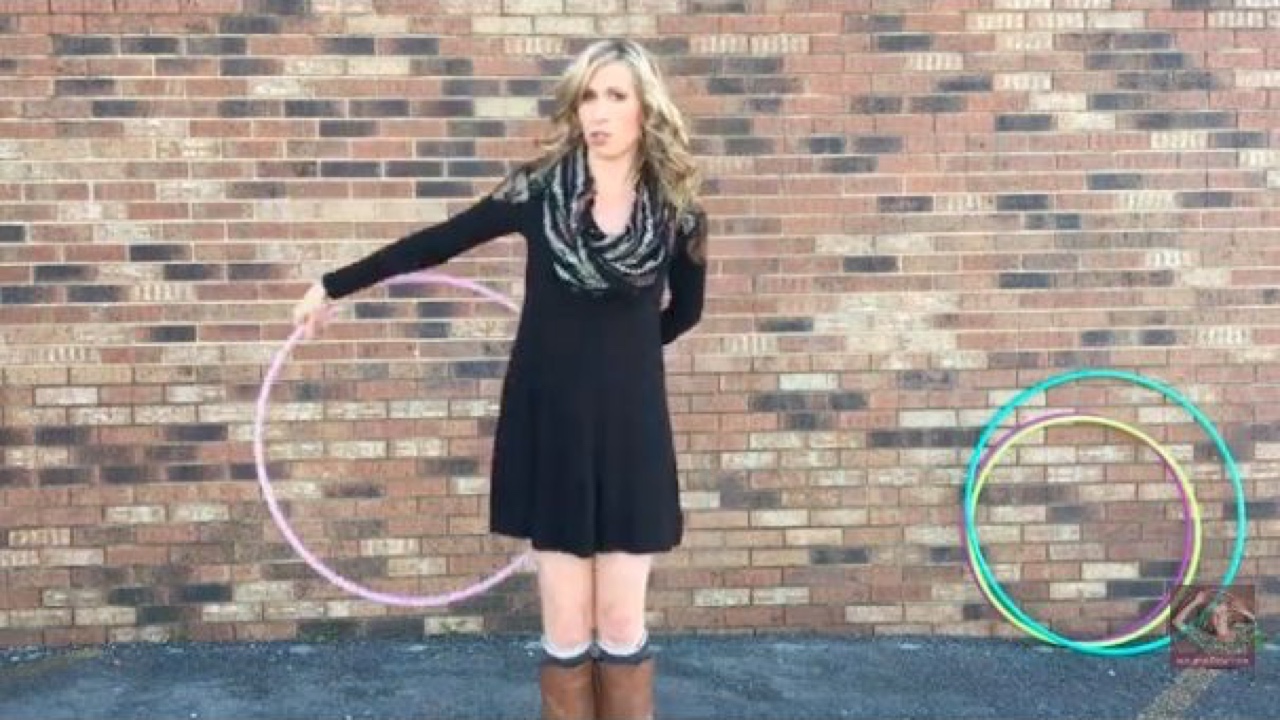 Michele McCoy guiding a pink hoop behind her back during a ghosting isolation demonstration.