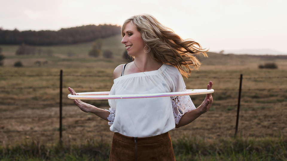 Michele McCoy hoop dancing outdoors in an autumn field